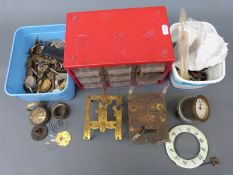 A large collection of watch and clock parts some in a small drawer unit.