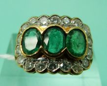 An 18ct gold ring set with three oval cut apple green emeralds each approximately 0.