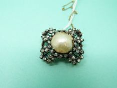 An early Victorian brooch set with a pearl cabochon to the centre surrounded by old mine cut