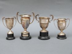 Four various mid 20thC twin handled trophy cups including an unengraved example,