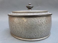 An oval Tudric pewter dressing table pot with hammered decoration, width 14.