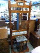 An Arts and Crafts style tile backed coat and stick stand with drip tray,