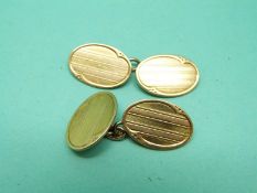 A pair of 15ct gold oval cufflinks with engine turned decoration, 10.