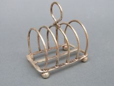 A small George V hallmarked silver four-slice toast rack, Sheffield 1914, maker Atkin Brothers,