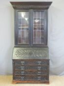 An oak carved bureau bookcase with leaded glass doors,