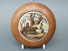 Prattware pot lid depicting bears or wolves, 7.5cm in diameter, in turned wooden frame.