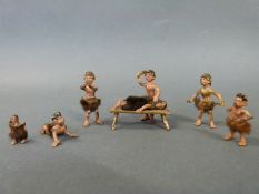 Six Austrian cold painted bronze miniature figures of cavemen including a lady on a bench being