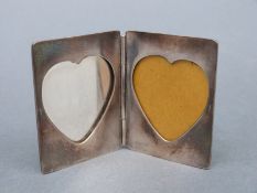 A Tiffany and Co white metal travelling photograph frame with heart shaped apertures, height 5.