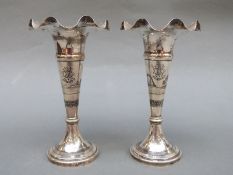 A pair of white metal Niello ware trumpet or spill vases with Iraq 1936-38 and desert scene to body,