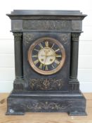 A large black slate mantel clock with open escapement