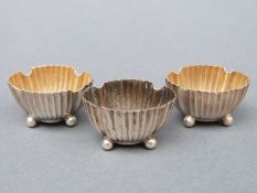 Three Victorian hallmarked silver open salts with ribbed bodies raised on four ball feet,