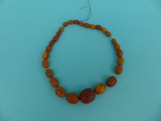 An amber necklace of graduated dark egg yolk coloured beads,
