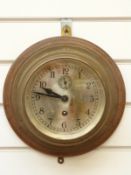 A brass cased ship's bulkhead clock with silvered Arabic dial,