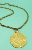 A yellow metal Islamic coin pendant, 12.