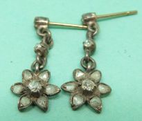 A pair of early 19thC gold and silver earrings set with old mine cut diamonds to the centre