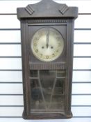 A c1930 Art Deco oak cased wall clock, the silvered dial with Arabic numerals and stylized hands,