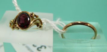 An Edwardian ring set with a garnet (size F) and a 9ct gold wedding band