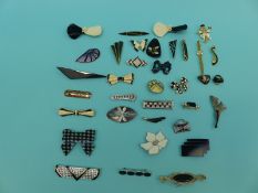 A collection of brooches including black and white examples,