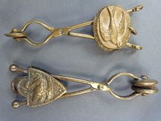 Two brass skirt lifters each with embossed bird decoration