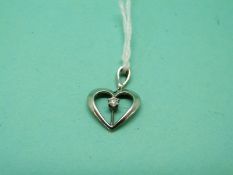 An 18ct white gold heart pendant set with a diamond