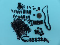 A collection of jet items and beads including a locket,