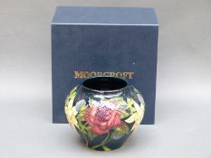A Moorcroft vase decorated with flowers, signed by Nicola Slaney and dated 2011, 11cm tall,