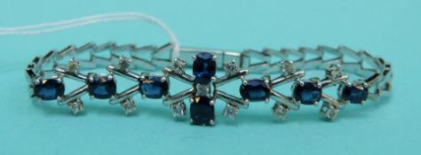 A 9ct white gold bracelet set with eight oval cut sapphires and thirteen white sapphires