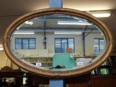 A gilt framed oval bevelled edge mirror,