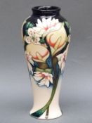 A Moorcroft vase decorated with flowers, signed by Nicola Slaney and dated 2010, 21.