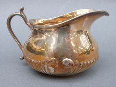 A Victorian hallmarked silver cream jug with fluted base, London 1898 maker Henry Stratford,