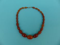 WITHDRAWN An amber necklace of graduated oval beads,