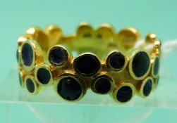 An 18ct gold ring set with circles of blue enamel (size Q), weight 5.