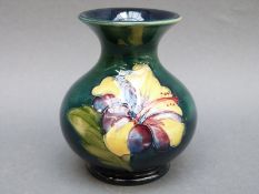 A Moorcroft vase in Hibiscus pattern on a green ground, 9.