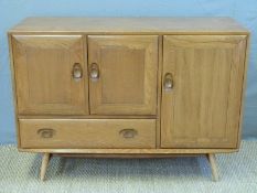 An Ercol light elm sideboard with double cupboard above a drawer and cupboard to side (W115 x D45 x