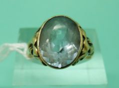 A yellow metal ring marked 333 set with a blue topaz (Size N)