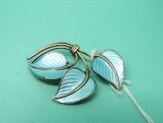A silver brooch in the form of three leaves set with blue enamel and marked Norway