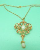 An Edwardian 15ct gold pendant set with seed pearls and two opal cabochons on a 15ct gold chain,