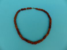 An amber necklace of barrel shaped beads,