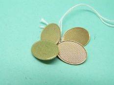 A pair of 9ct gold oval cufflinks with engine turned decoration, 7.