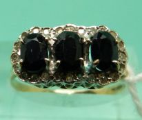 A 9ct gold ring set with 3 oval sapphires surrounded by diamonds (size P)