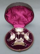 A cased set of Walker & Hall Victorian hallmarked silver two handled green salts,