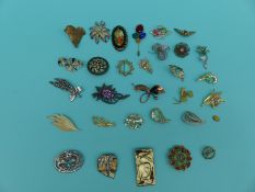 A collection of floral and foliate design brooches to include Sara Coventry and a signed Russian
