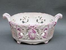 A pierced twin handled bowl or basket with hand painted continental scenes,