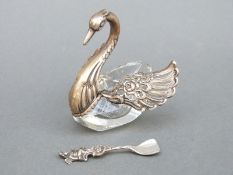 A glass and white metal novelty salt in the form of a swan with articulated wings, marked 835,