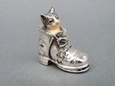An enamel cat emerging from a hallmarked silver boot, height 3.
