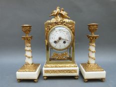 A continental gilt metal mounted clock garniture with bevelled glass panels and painted dial,