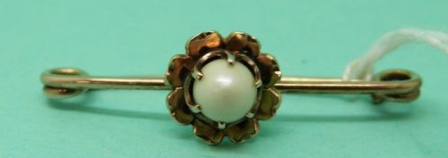 A 9ct gold brooch in the form of a flower with a freshwater pearl to the centre