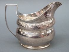 A Georgian hallmarked silver cream jug with chased decoration, marks rubbed but circa early 19thC,