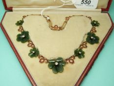 A 9ct gold necklace made up of jade clover leaves set with a diamond to the centre of each and