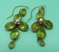 A pair of 15ct gold Edwardian earrings set with oval and round cut peridot and a pearl in a foliate